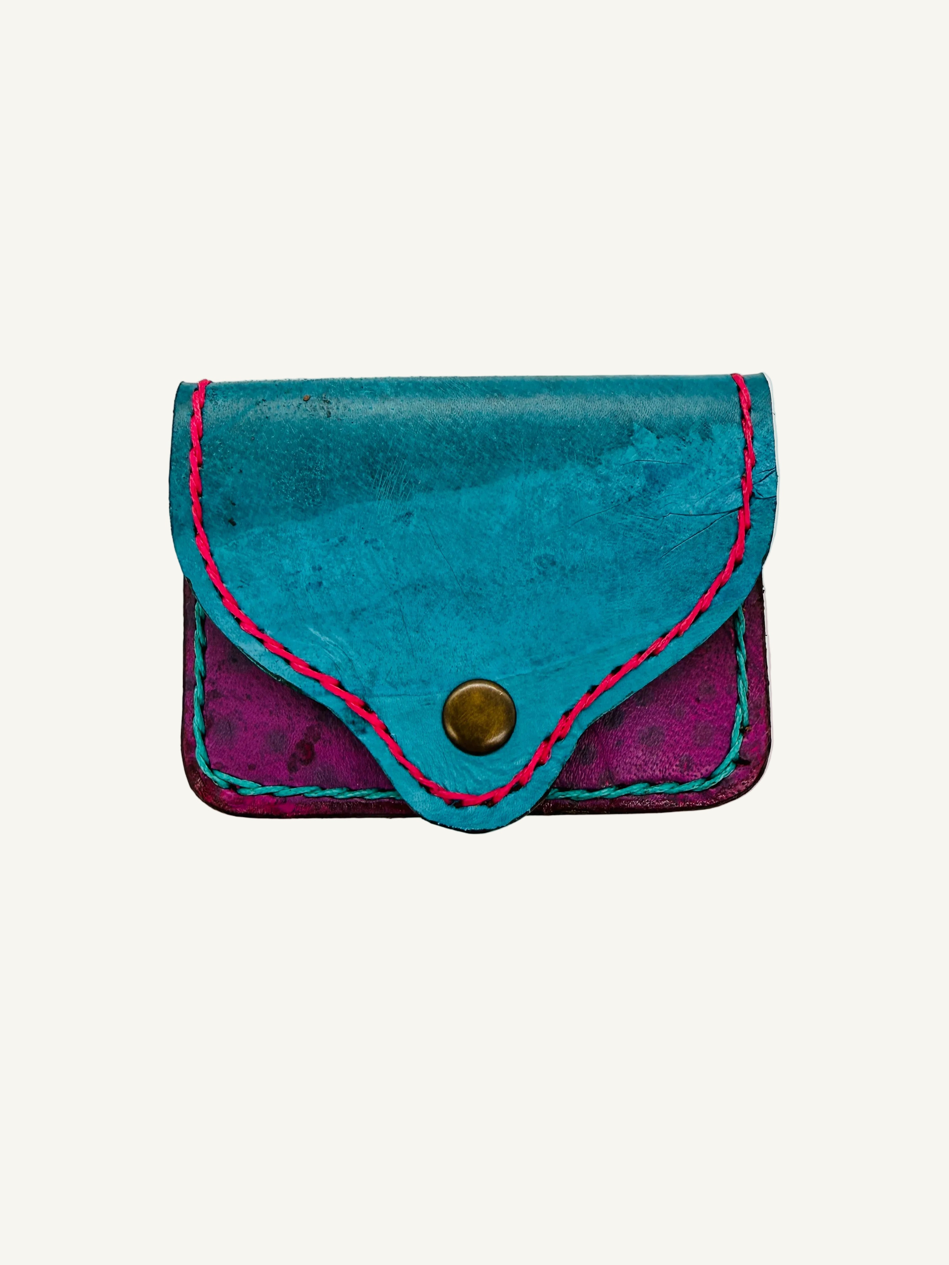 Small blue and purple leather pouch with a button on a white background