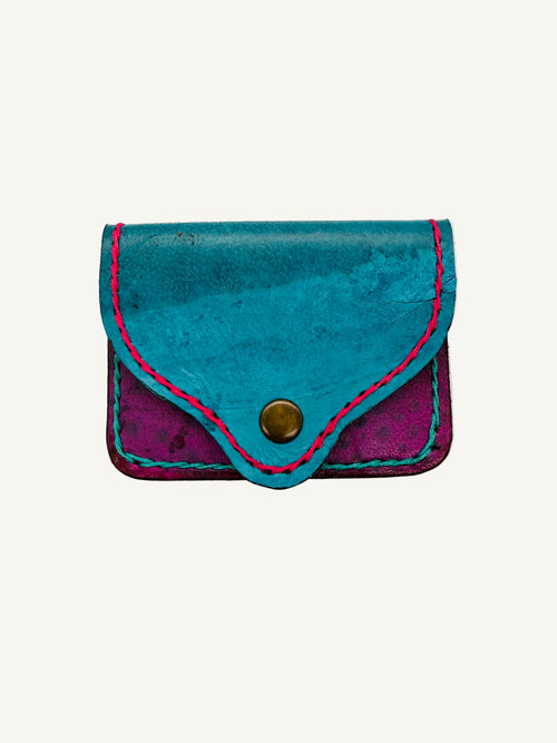 Small blue and purple leather pouch with a button on a white background